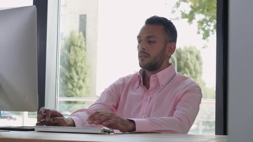 Man Typing on Computer Keyboard in Modern Office