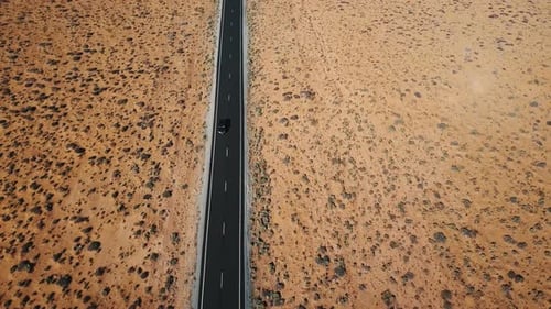 Drone Follows Silver Car Driving Along Dry American Desert Landscape Highway