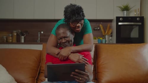 Senior Couple Relaxing with Tablet on Sofa