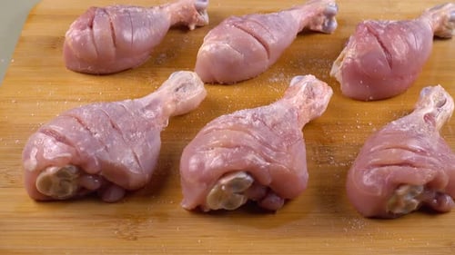 Der Prozess des Beizens von Hähnchenschenkeln auf einem Schneidebrett