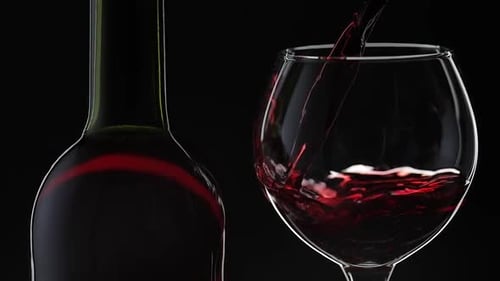 Rose Wine. Red Wine Pour in Wine Glass Over Black Background. Slow Motion