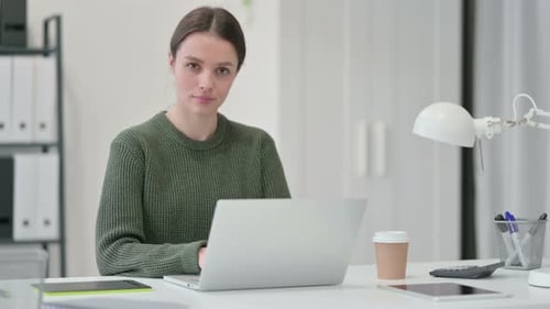 Young Woman Working on Laptop at Office Desk