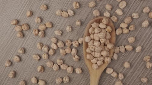 Raw Chickpeas in Wooden Spoon on Table