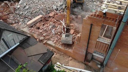 Excavator Digs Rubbles of Abandoned Cottage at District