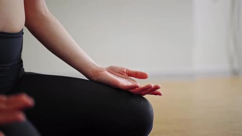 Close up: athletic woman doing yoga for health. The girl is in the lotus position
