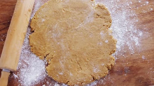 Cookie Dough and Rolling Pin on Wooden Board