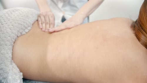 Woman Receiving a Professional Back Massage in Spa