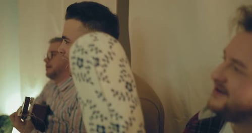 Adults singing and playing guitar together