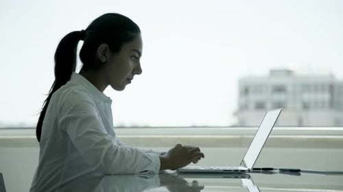 Fokussierte junge Geschäftsfrau nutzt Laptop