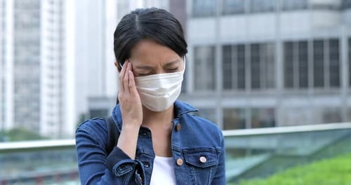 Woman Coughing While Wearing Mask in the City