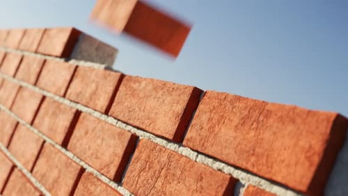 La pared de ladrillos de arcilla que se está construyendo sobre un fondo de cielo azul claro. Se puede enredar