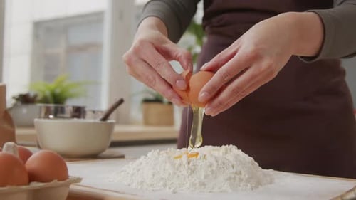 Cracking an Egg into Flour for Baking