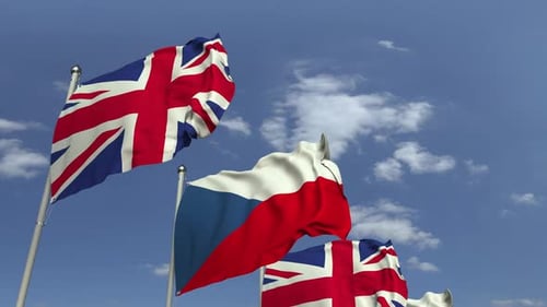 Waving Flags of United Kingdom and Czech Republic Against Blue Sky