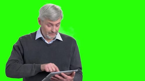 Man Uses Tablet in Front of Green Screen