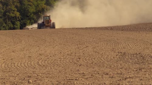 Tractor plowing field in slow motion