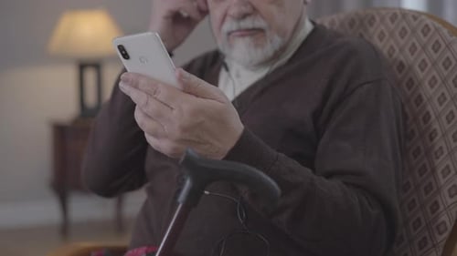 Senior Man Watching Content on Smartphone