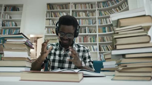 Young Adult Studying Hard in Library with Books