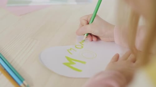 Child Draws Mother's Day Card with Green Pencil