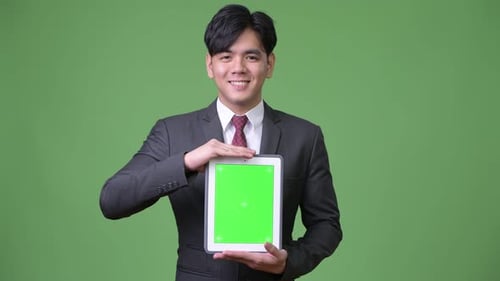 Young Adult Presenting Tablet with Green Screen