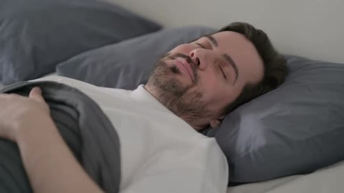 Young Man Sleeping in Bed Peacefully