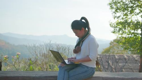 Young Woman Working on Laptop in the Mountains