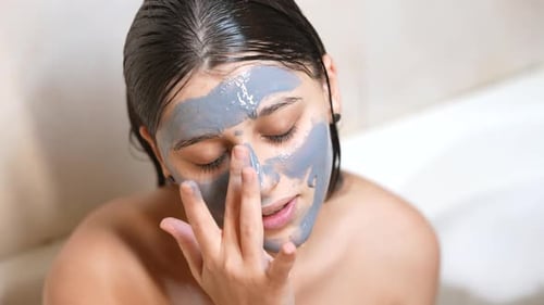 Woman Applying Mud Mask to Her Face
