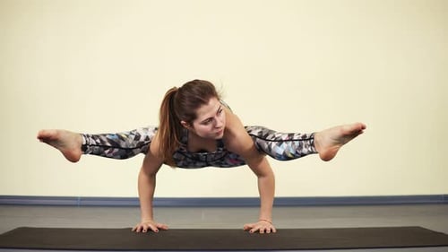 Woman Practicing Advanced Yoga Pose on Yoga Mat