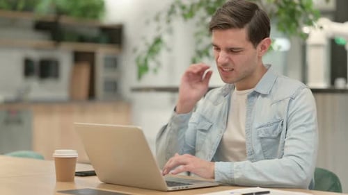Young Adult Working At A Laptop On Desk