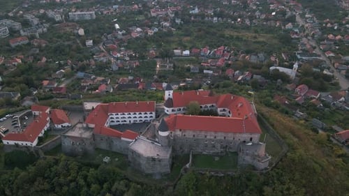 Luftaufnahme der mittelalterlichen Burg auf einem Berg in einer kleinen europäischen Stadt am bewölkten Herbsttag