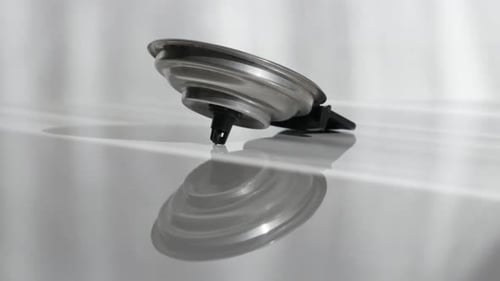 Silver Metal Lid Close Up on Reflective Surface