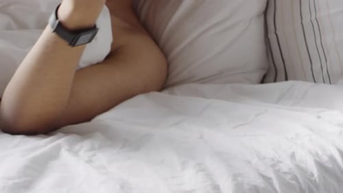 Man Talking on Phone in Bed