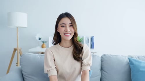 Smiling Woman Posing on Couch in Bright Home