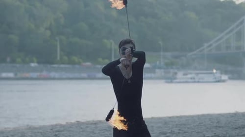 Young Adult Fire Performer on Beach with Flames