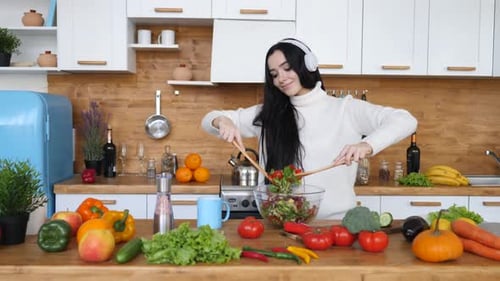 Woman Mixing Fresh Salad in Bright Kitchen
