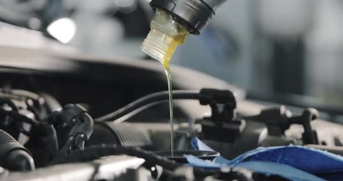 Nahaufnahme des Ölkanisters. Autoservice-Mitarbeiter wechseln Öl im Auto