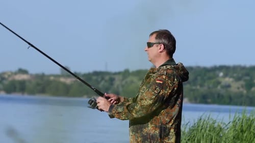 Fischer hält eine Angelrute in der Hand und fängt Fische als Köder
