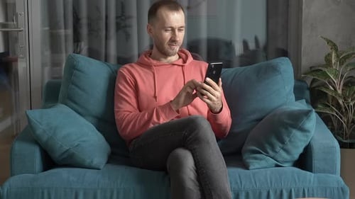 Man Using Smartphone While Sitting on Couch