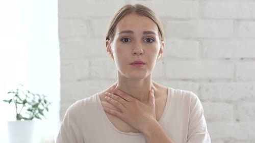 Woman Has a Sore Throat Indoors