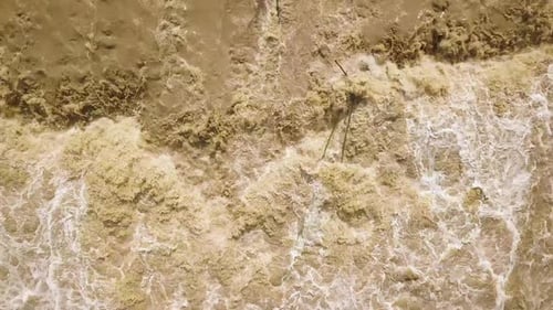 Luftaufnahme eines breiten, schmutzigen Flusses mit schlammigem Wasser während der Überschwemmungszeit bei starken Regenfällen im Frühling