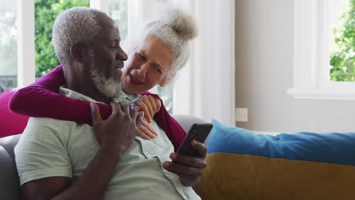 Mature Couple Laughing Together at Smartphone Content