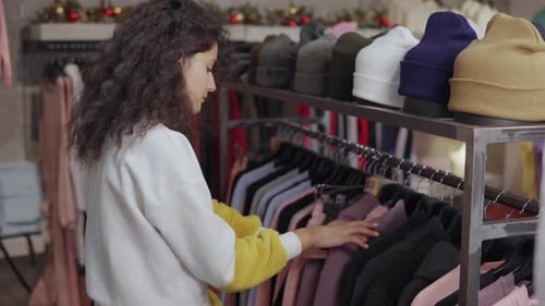 Female Buyer Is Choosing Warm Trendy Clothing in Hall of Store