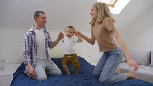 Happy Family Jumping on a Bed Together