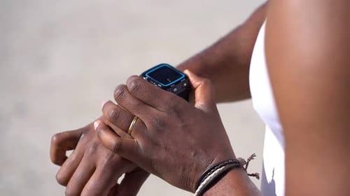 Man Looks at Smartwatch on Sunny Day