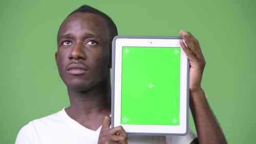 Young Adult Holding Tablet with Green Screen