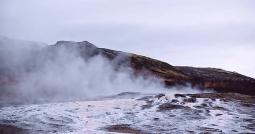 Steam Rising From Thermal Pool In Snowy Landscape