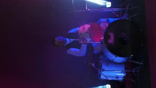 Cool Grunge Rock Musician Playing Drums on Stage, Doing an Amazing Metal Solo, Lit By Club Neon Red