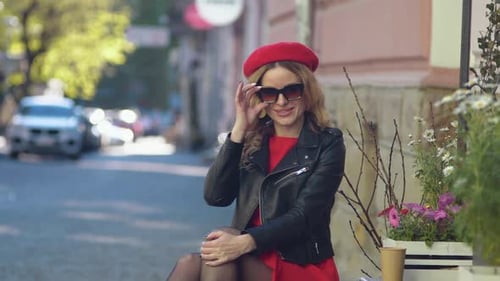 Stylish Woman Sitting on Bench in Urban Setting