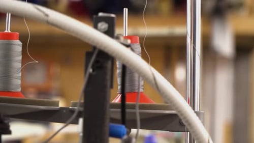Close up of industrial sewing machine spools and thread