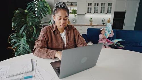 Young Serious African American Woman Entrepreneur Working Online From Home Her Little Daughter