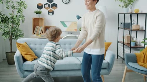 Slow Motion of Joyful Child Dancing with Young Active Mother Having Fun Together at Home